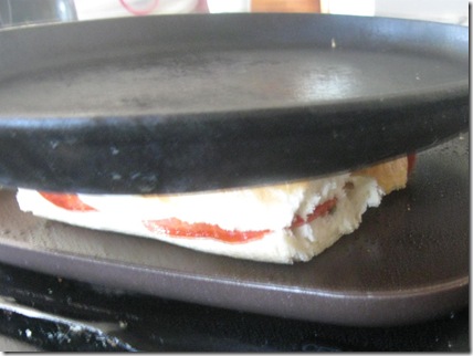 Sandwich being pressed with cast iron