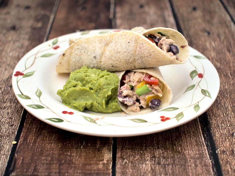 Southwestern Tuna Wrap - an easy and healthy lunch idea featuring tuna fish with black beans, tomatoes and cilantro, with a Greek yogurt dressing, wrapped in corn tortillas.