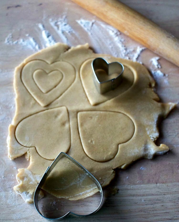 Rolling out heart shaped sandwich cookies