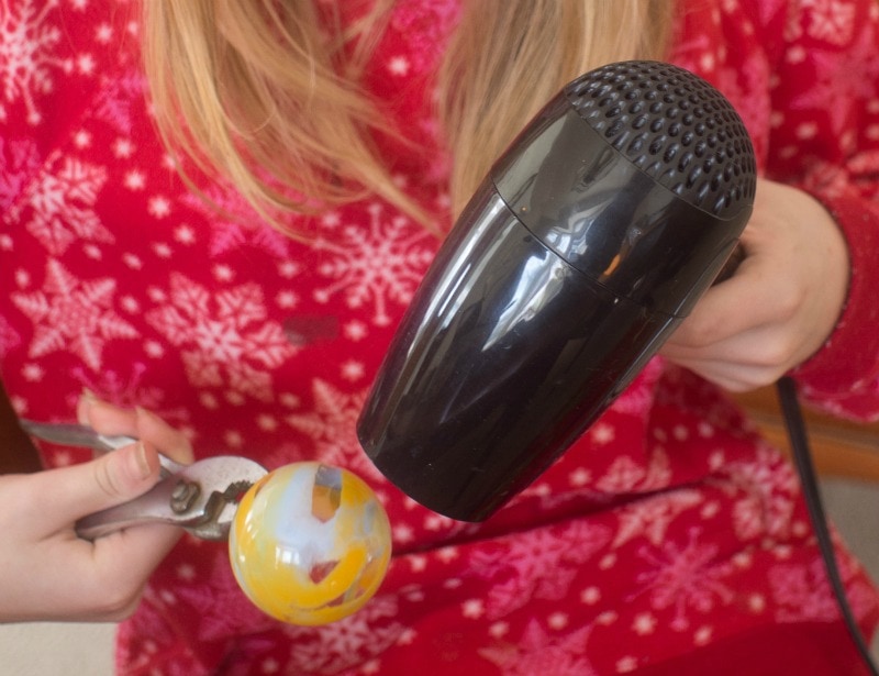 Demonstrating how to make melted crayon glass ornaments