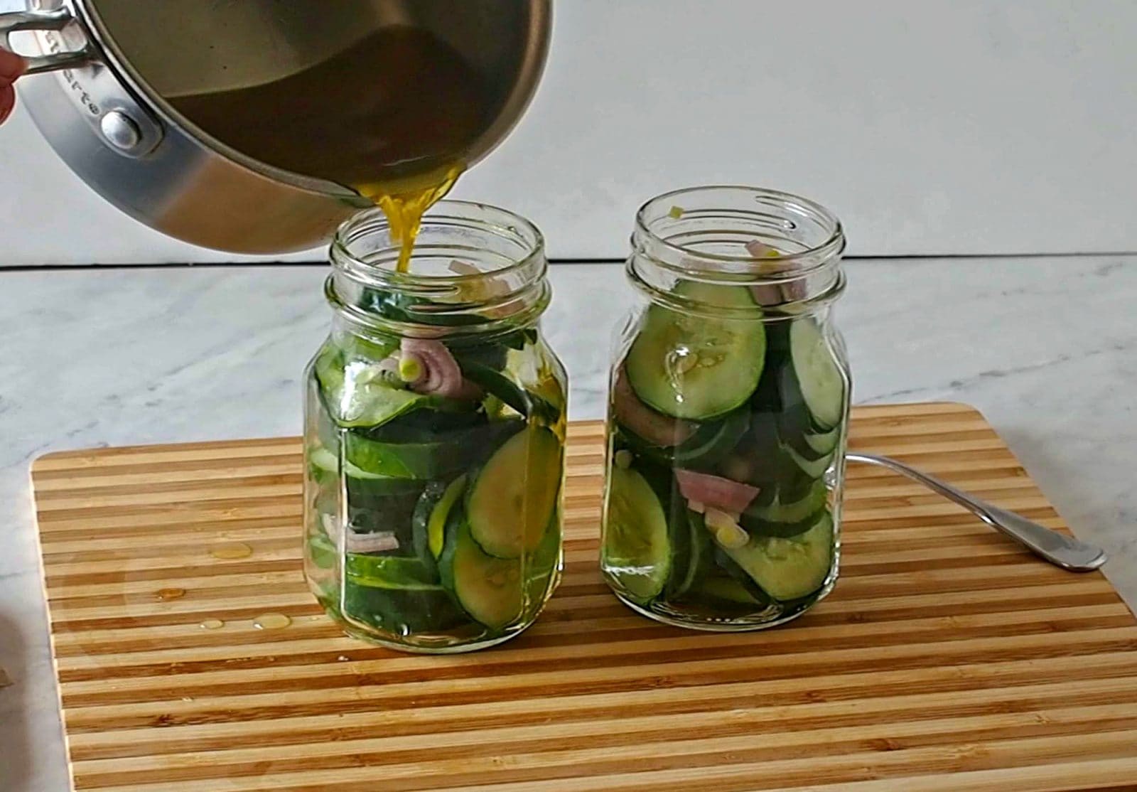 Making refrigerator bread and butter pickles by pouring brine over the cucumbers