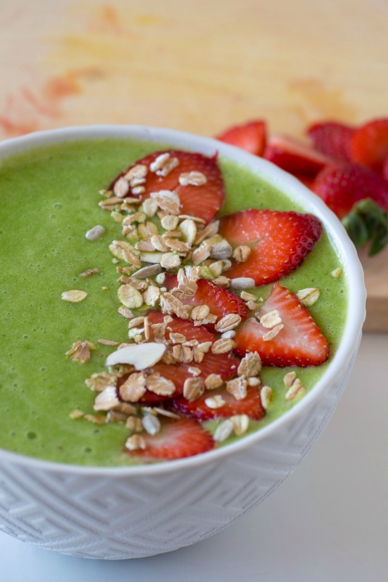 This vegan Green Smoothie Bowl with berries combines pineapple, orange, spinach and strawberries for a tasty and healthy breakfast meal that is full of fruit and ready in just a few minutes. #smoothiebowl #greensmoothiebowl #breakfast