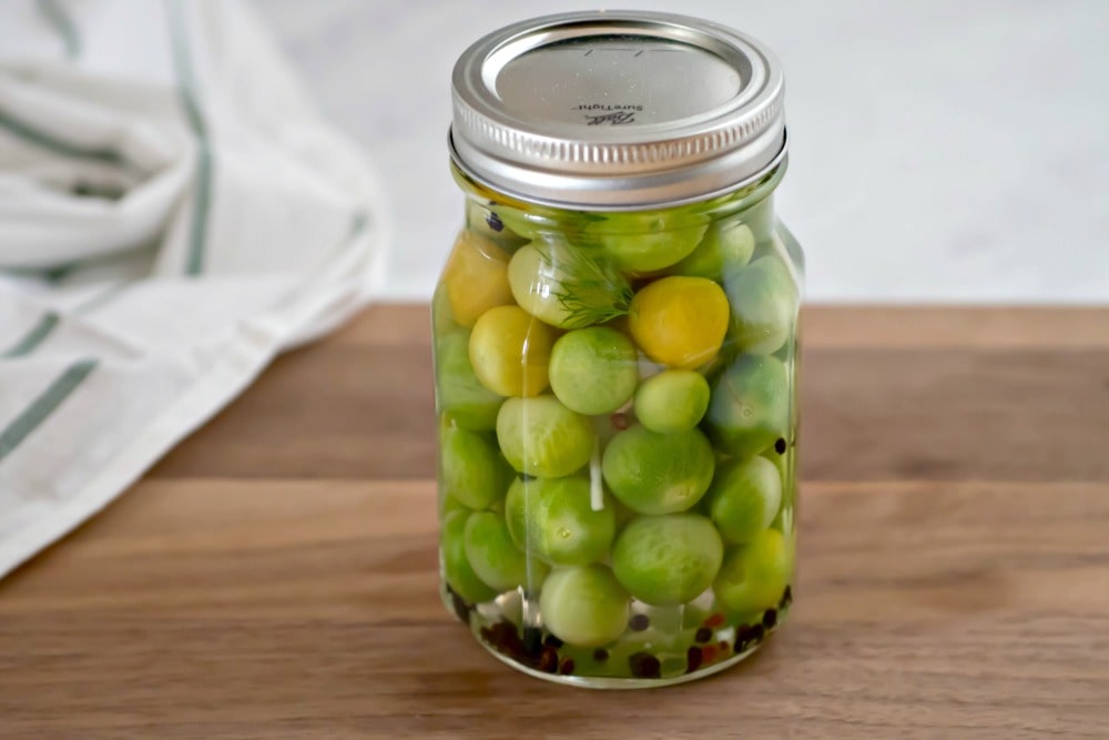 Mason jar with pickled green cherry tomatoes
