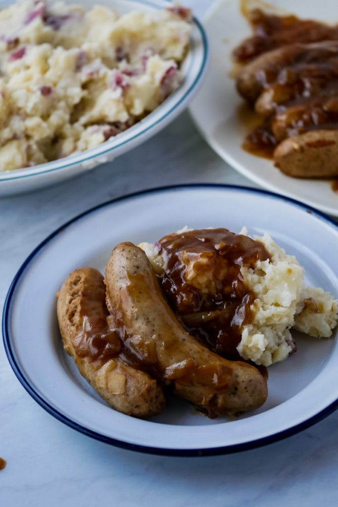 bangers and mash with serving platters in the background