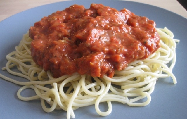 A plate with spaghetti and sauce on it.
