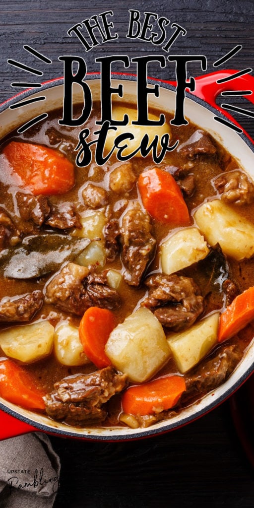 beef stew with potatoes and onions in a red pot