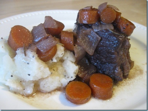 A plate with roast beef and carrots on it.