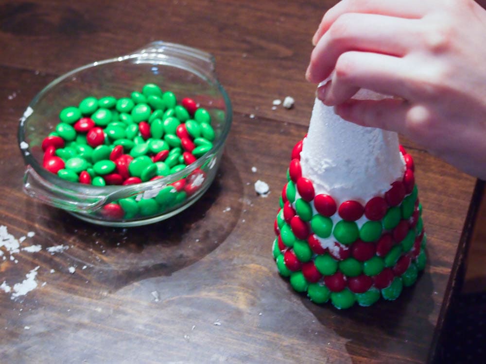 A person is making a christmas tree out of candy canes.