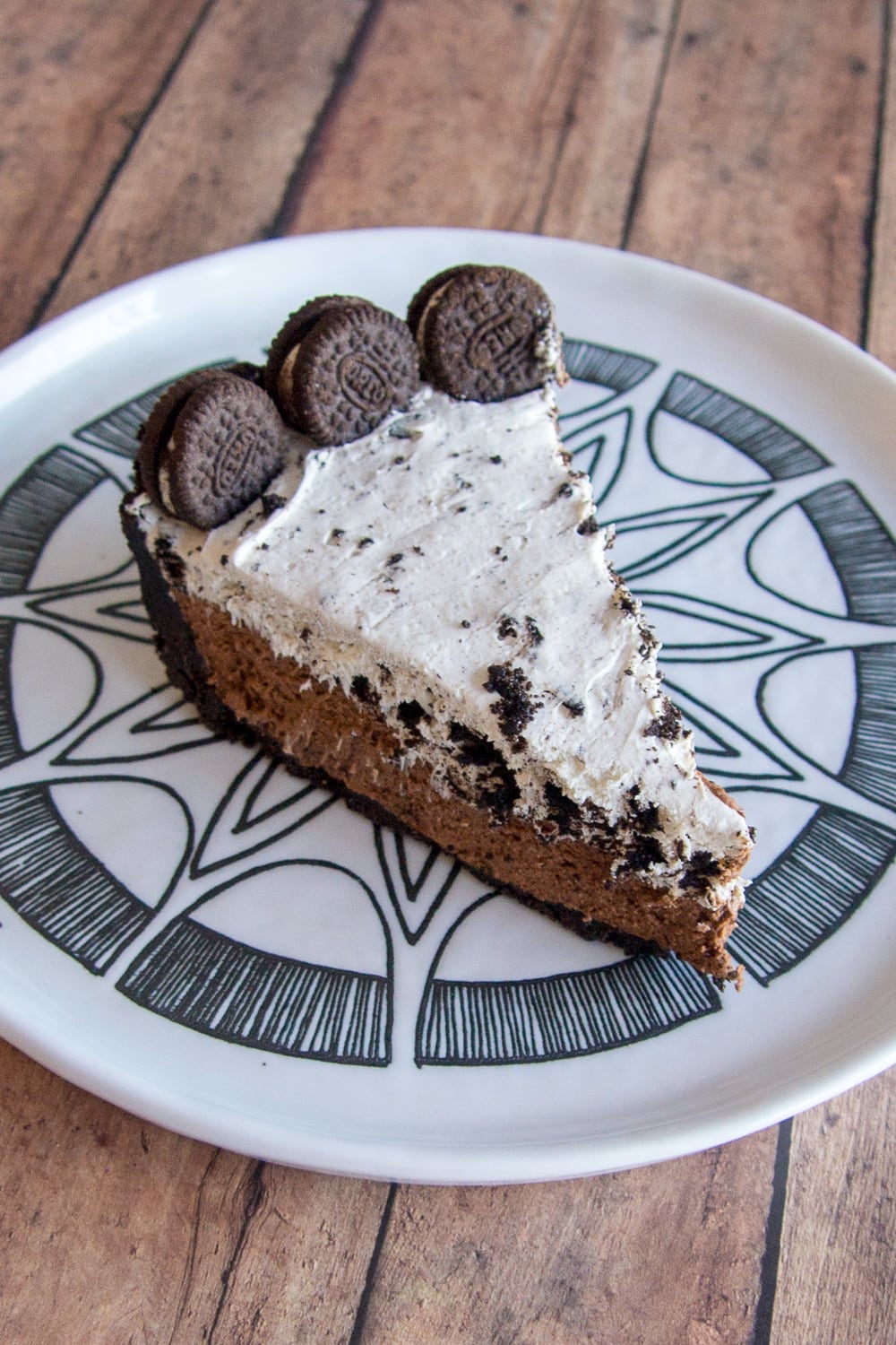 A slice of chocolate oreo cheesecake on a plate.