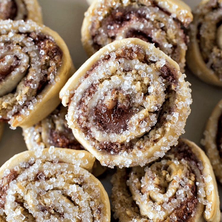 A plate of cinnamon roll raspberry pinwheel cookies with sugar on top.