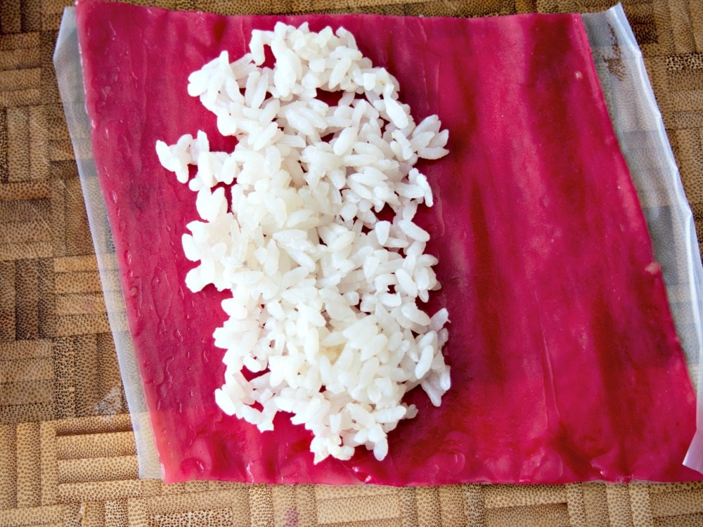 Adding rice to the fruit roll up for fruit sushi