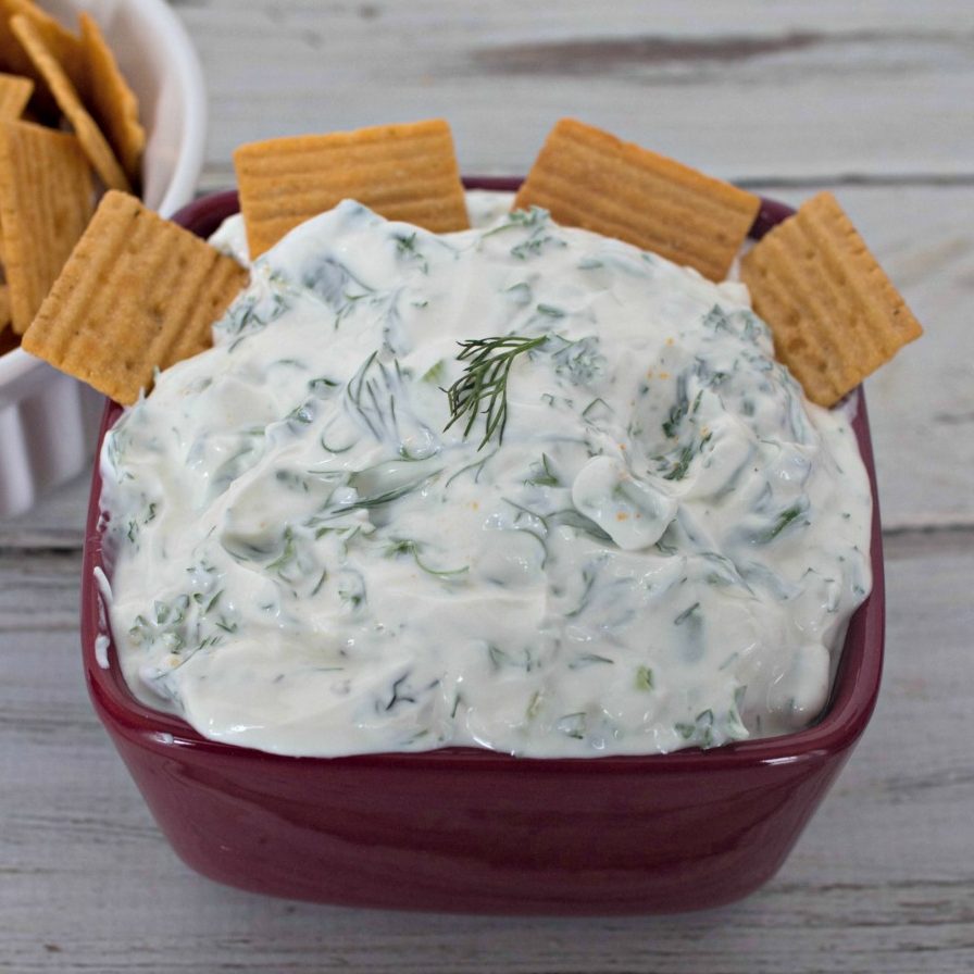 Onion dill dip in a red bowl with cheezits.