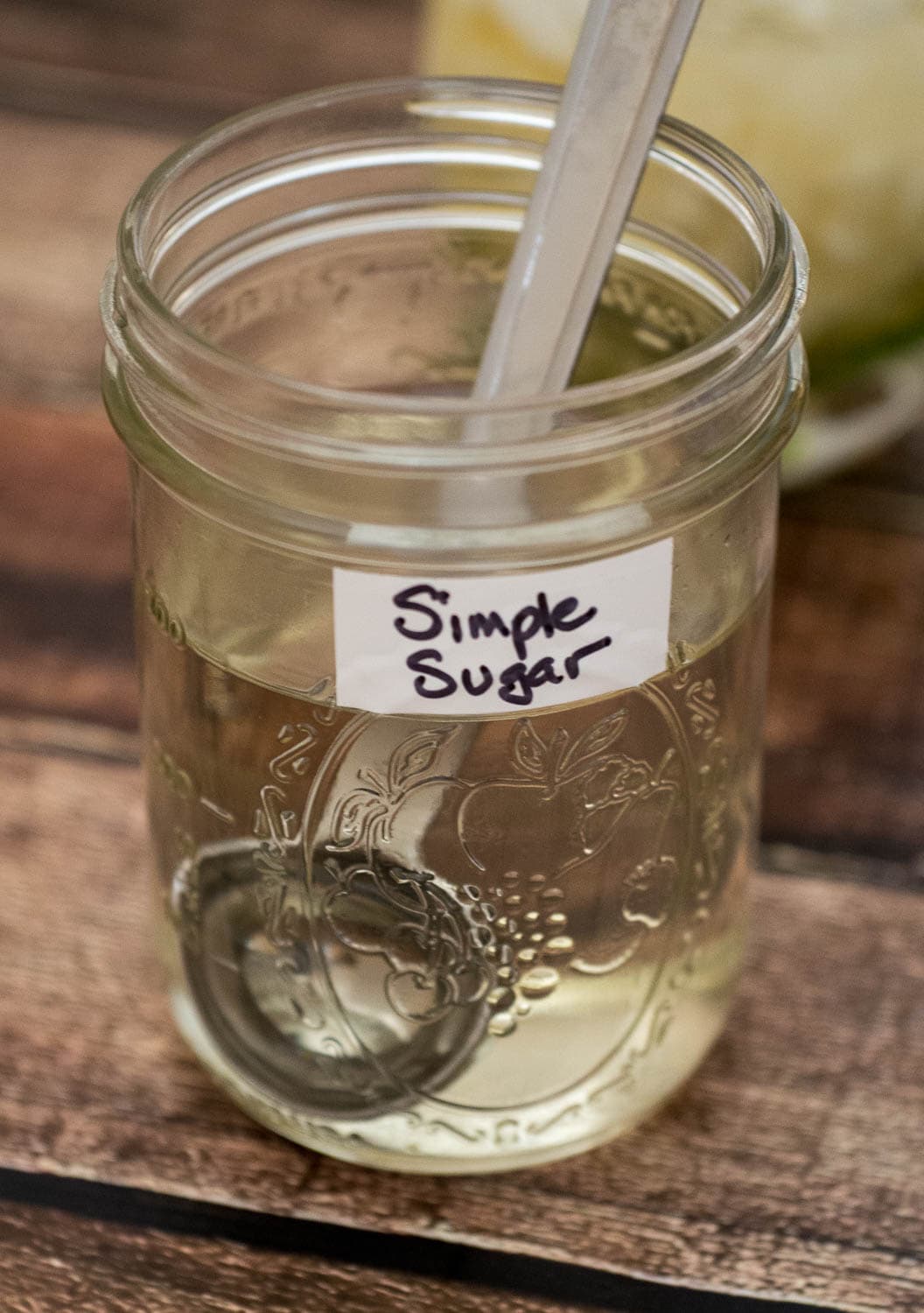 Simple syrup jar with a spoon for Mint Julep recipe.
