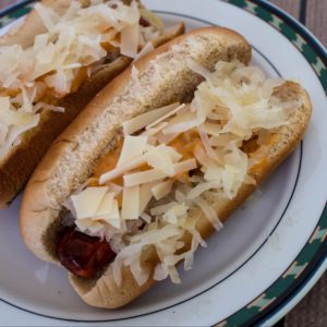 Reuben Hot Dog with sauerkraut and cheese on a plate.