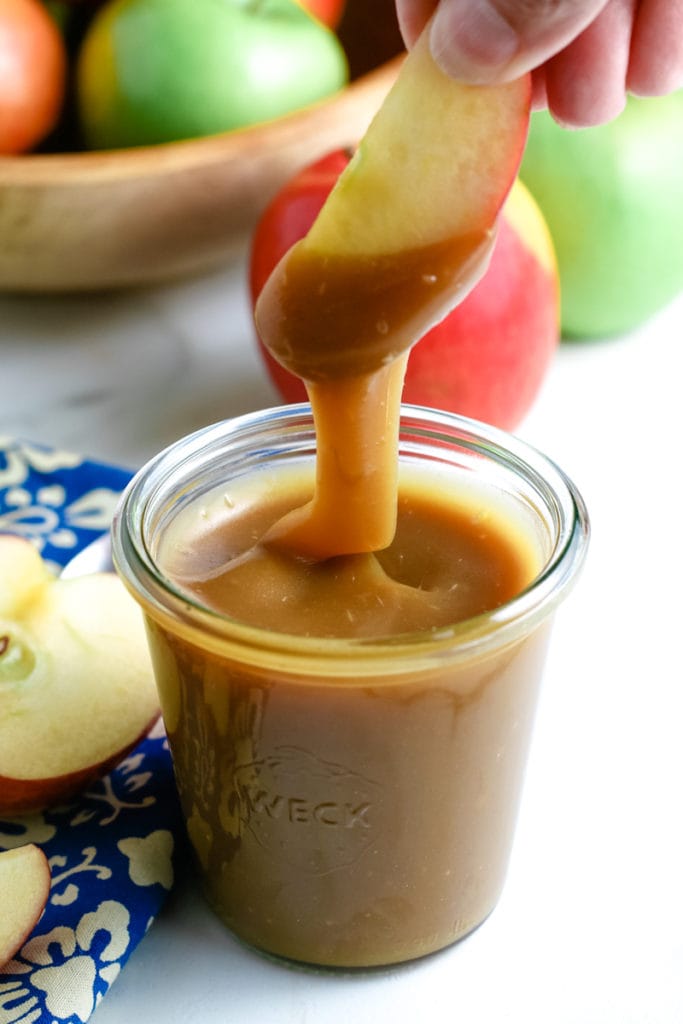 dipping apples into caramel