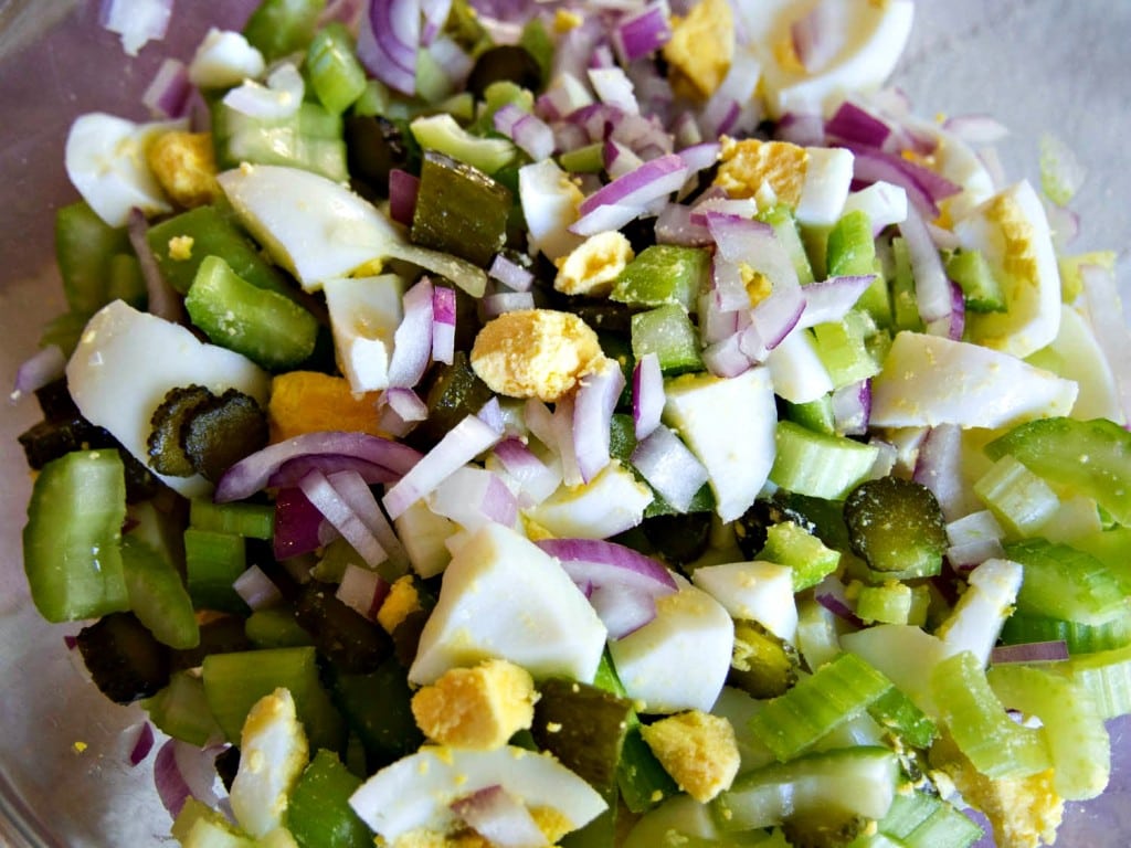chopped up ingredients for making the potato salad - pickles, celery, eggs, onions