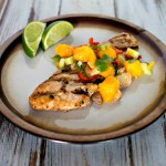 Grilled turkey cutlets with mango salsa on a plate.