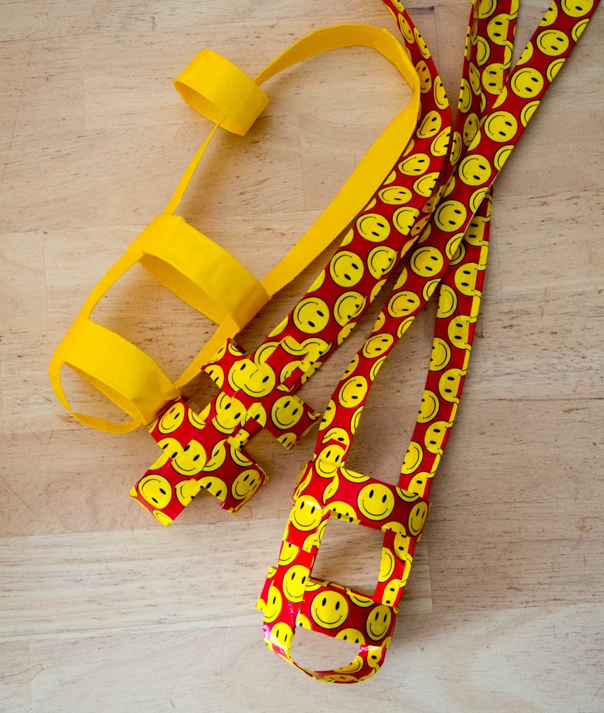 A yellow dog leash with smiley faces on it.
