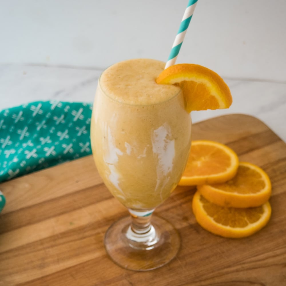 glass of creamsicle smoothie with a straw
