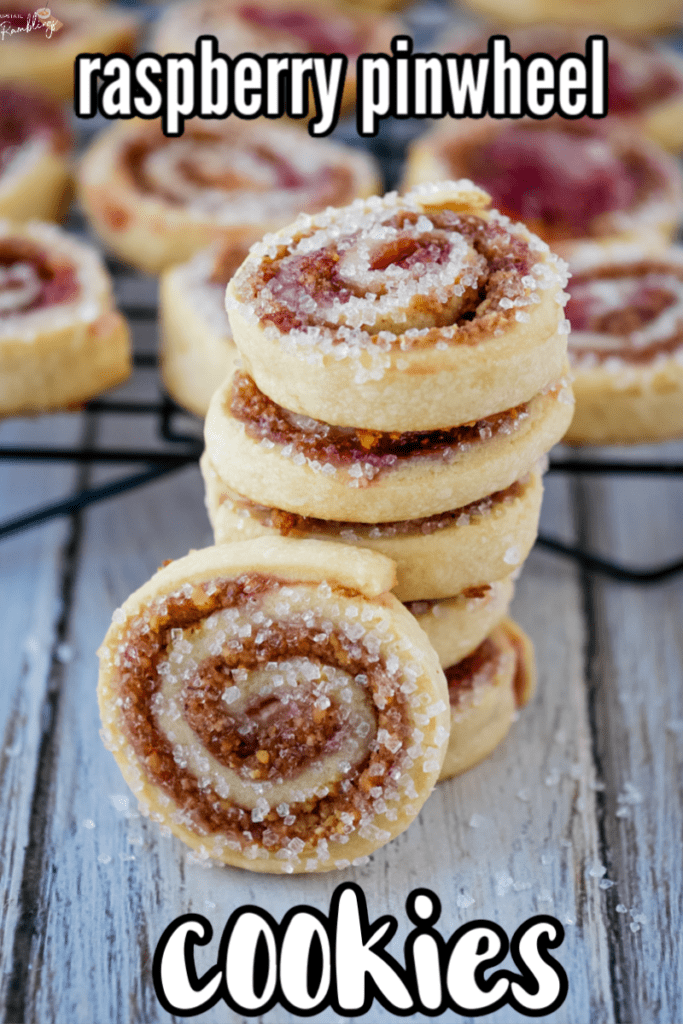 stack of raspberry pinwheel cookies in front of a cooling rack full of cookies with a text overlay