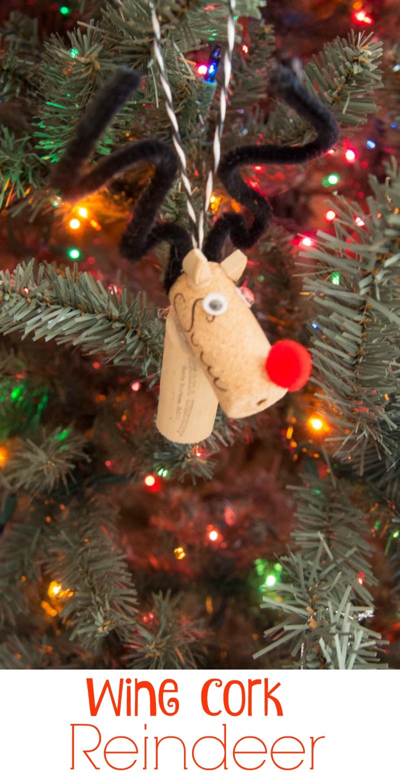 A wine cork reindeer ornament hanging on a Christmas tree.
