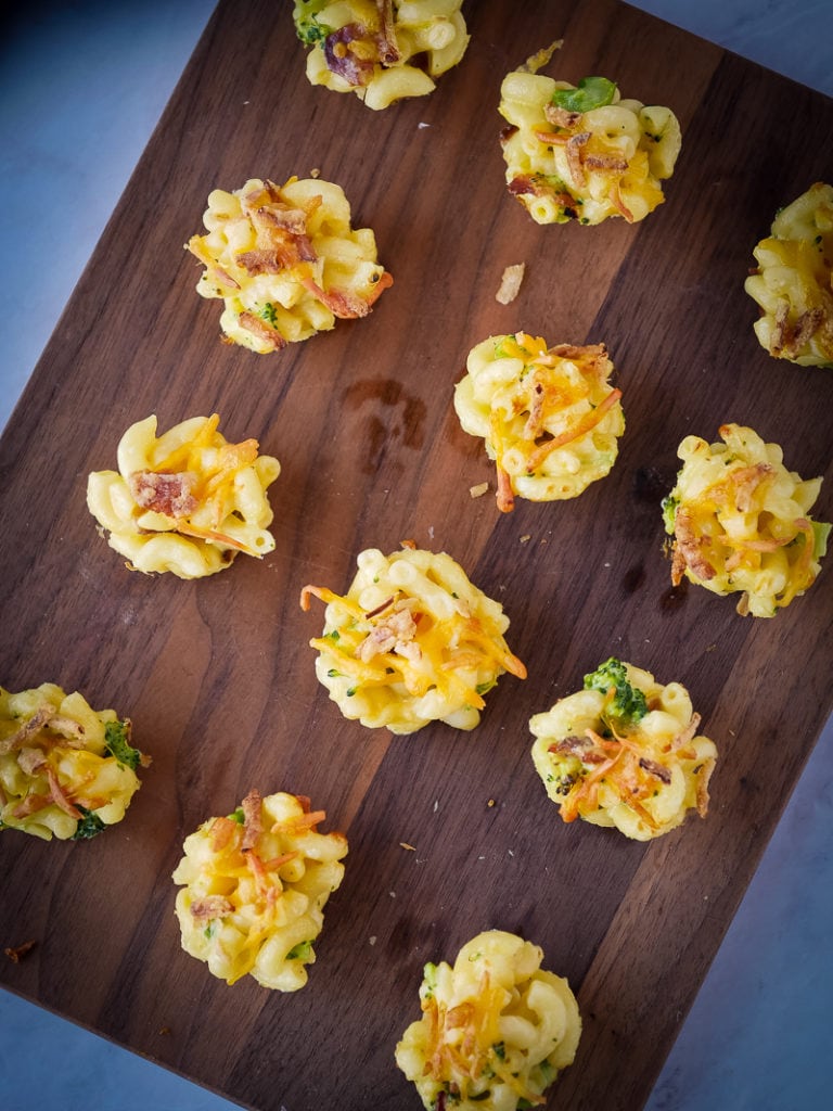 mac and cheese bites on a wooden cutting board