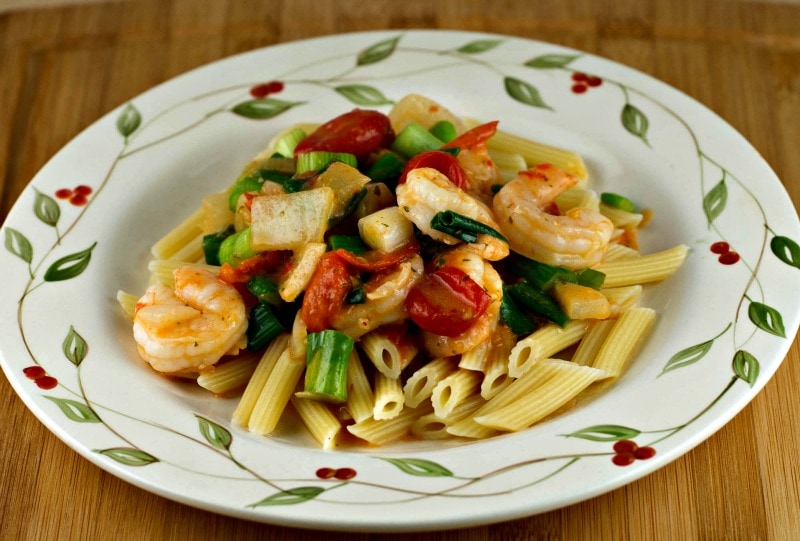 A plate of pasta with shrimp and vegetables on it.