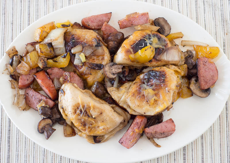 Grilled chicken with mushrooms and onions on a white plate.