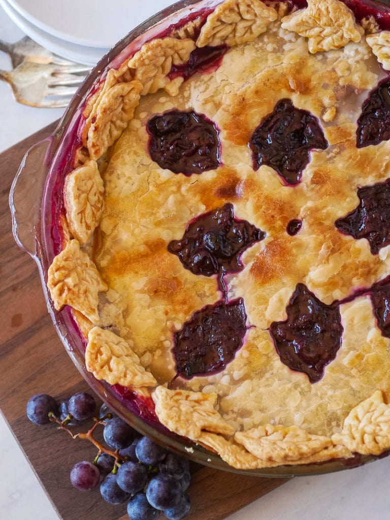 top view of grape pie with grapes on a cutting board