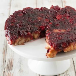 A pie with cranberry sauce on top of a white plate.