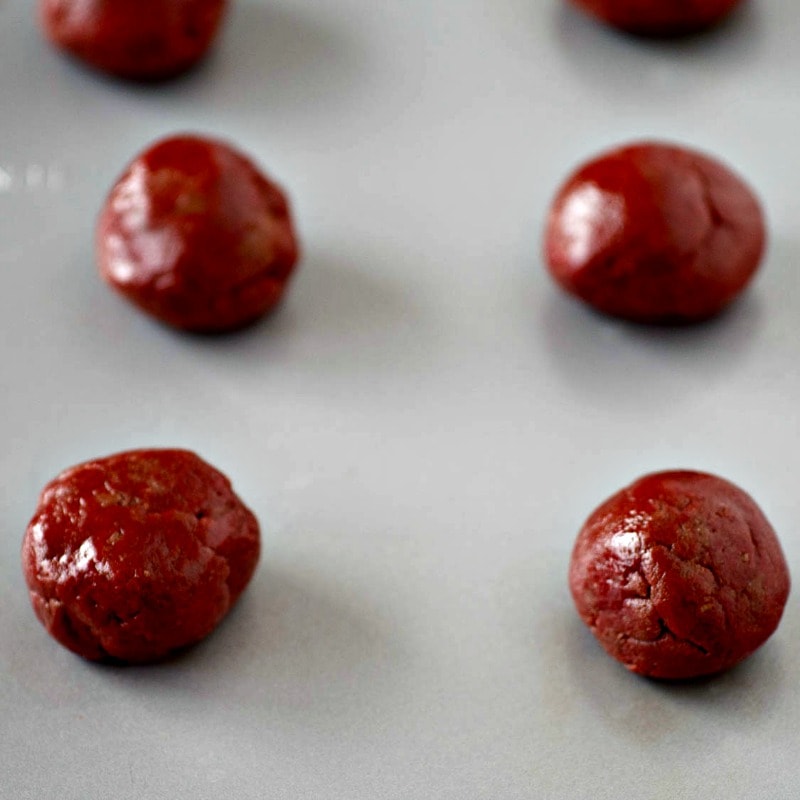 Red chocolate balls on a baking sheet.