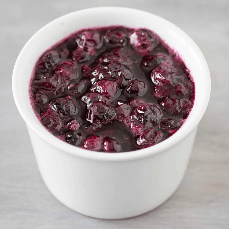Homemade blueberry sauce in a white bowl.