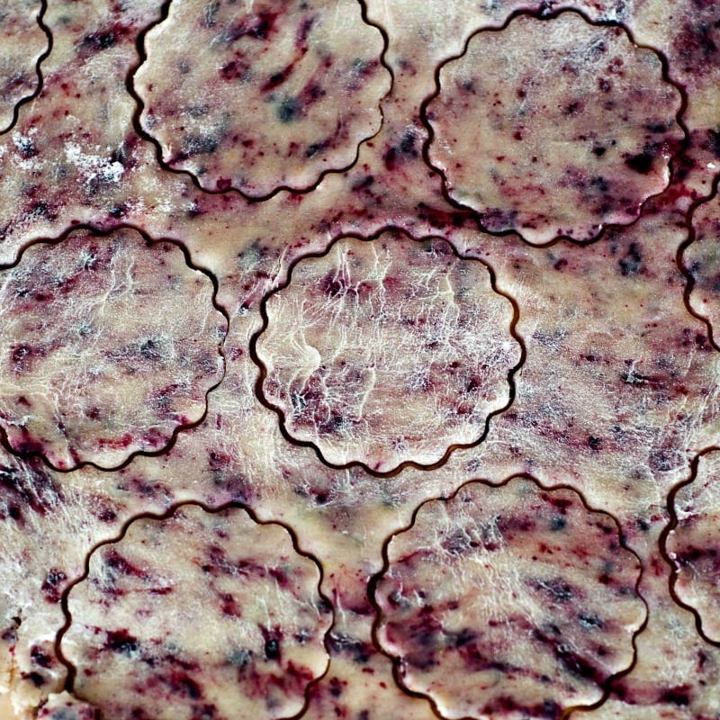 A close up of blueberry cookies on a baking sheet.