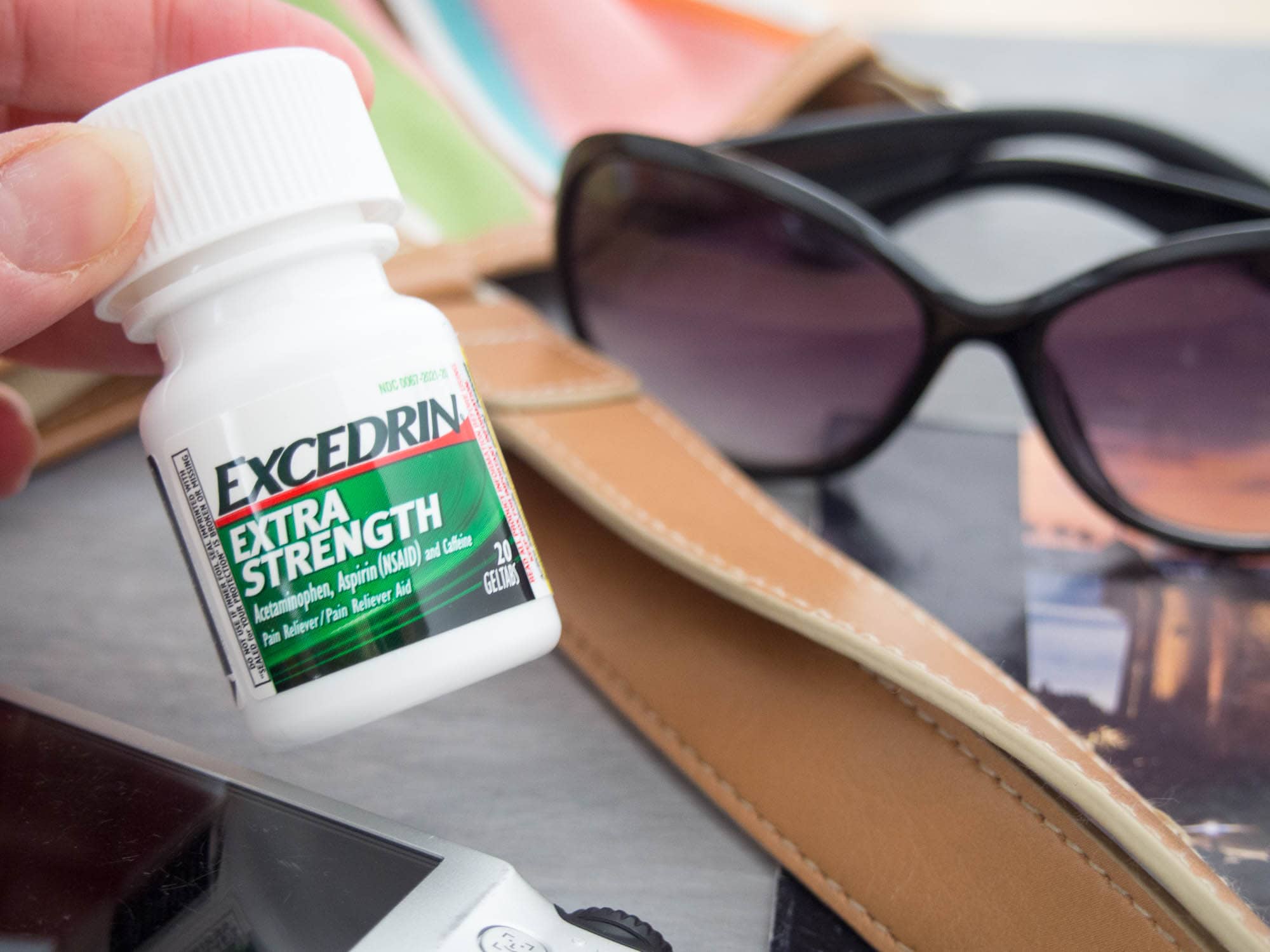 A person holding a bottle of excedrin extra strength.