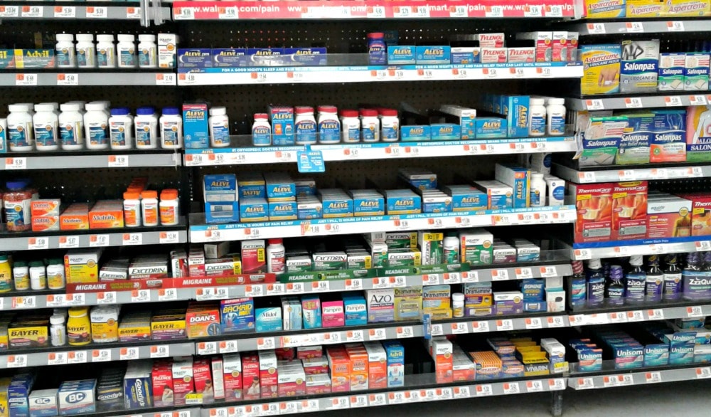 A row of shelves in a store filled with different types of medicine.