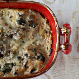 A casserole dish filled with spinach and mushrooms.