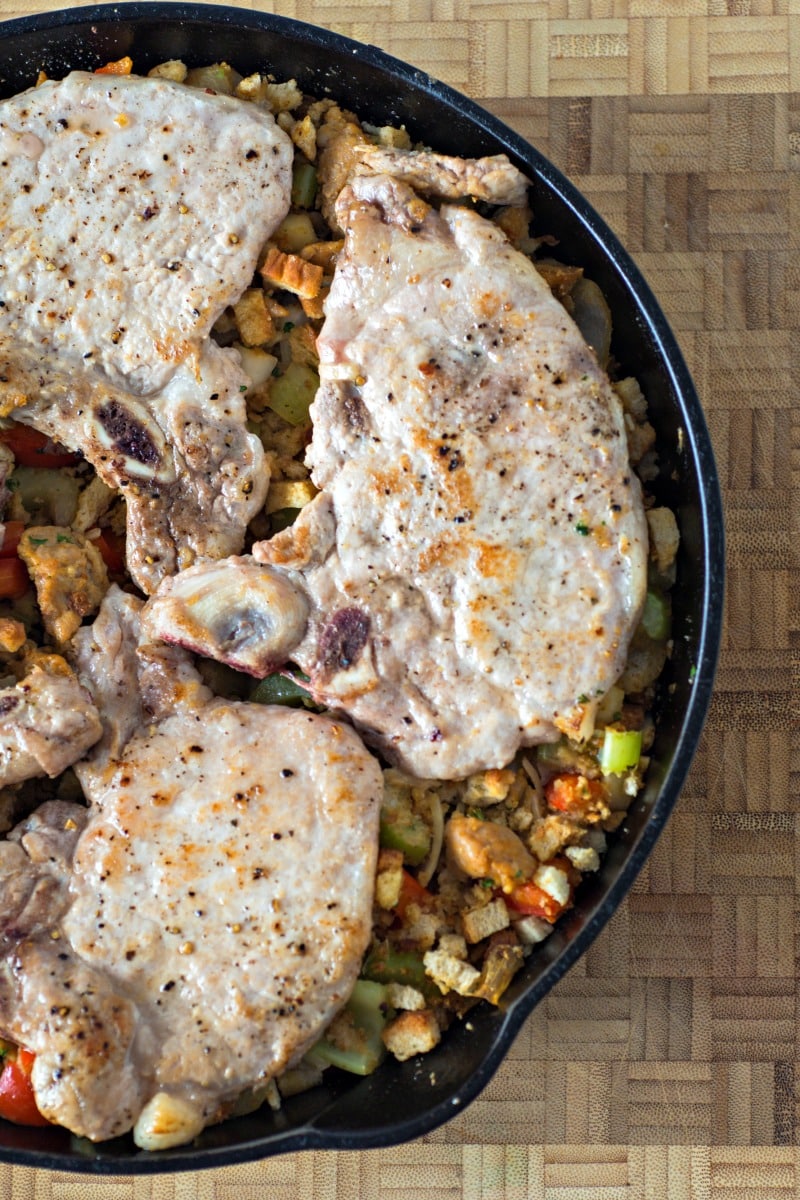 Check out this recipe for cast iron skillet pork chops with stuffing! It is a quick and easy family meal cooked in a cast iron skillet for an easy one dish meal. #castiron #castironskillet #porkchops #dinner #onedishmeal