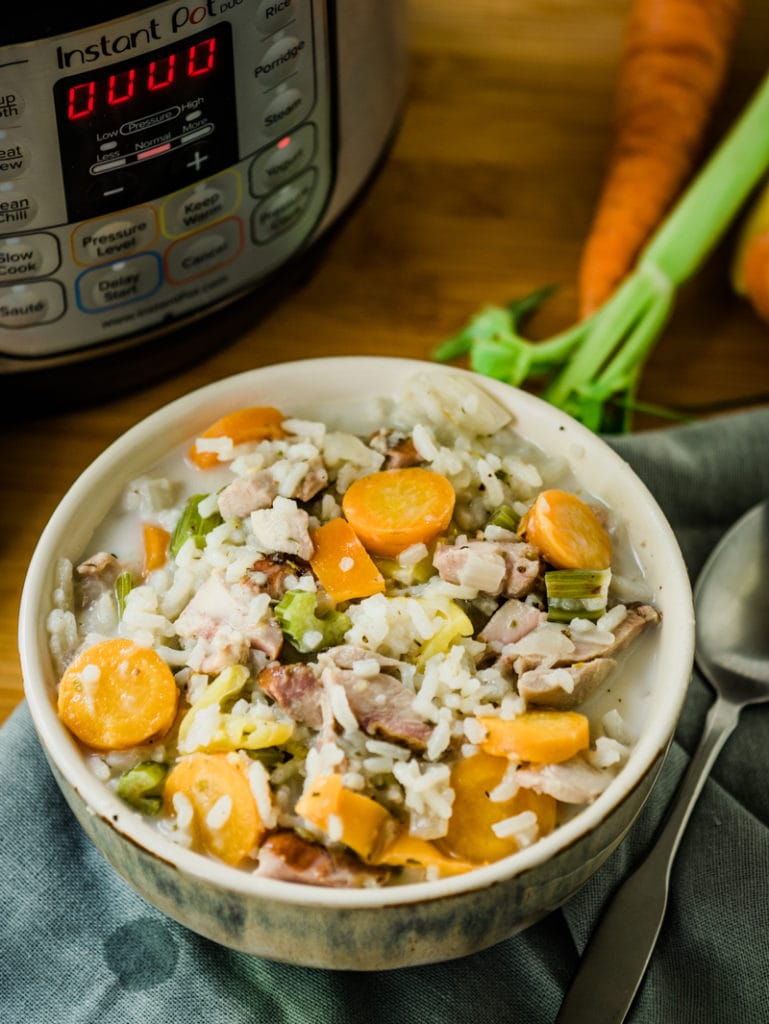 Instant pot turkey soup with rice in front of pressure cooker