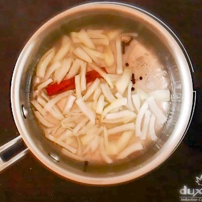 onion and cinnamon stick in sauce pan with brine