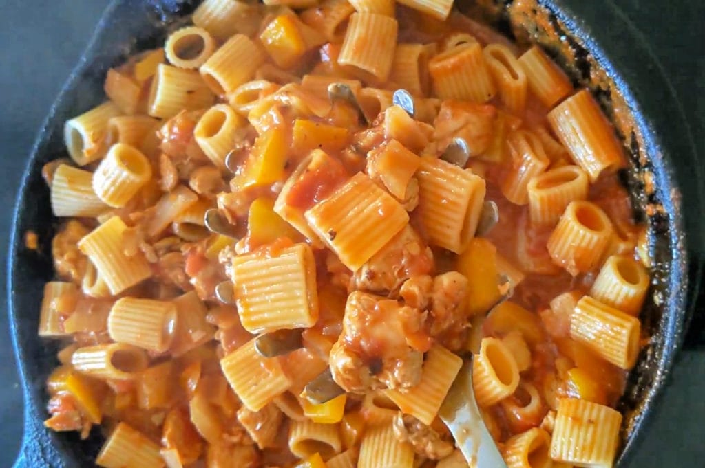 mixing the rigatoni into the riggies in a skillet