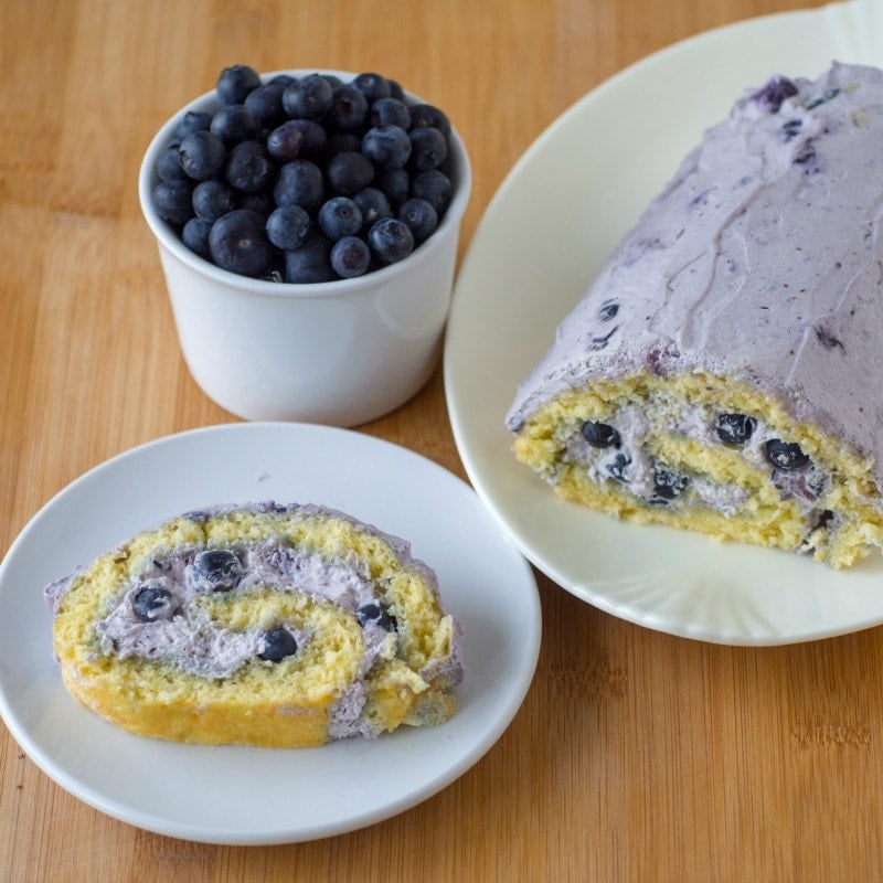 A slice of blueberry roll cake on a plate.