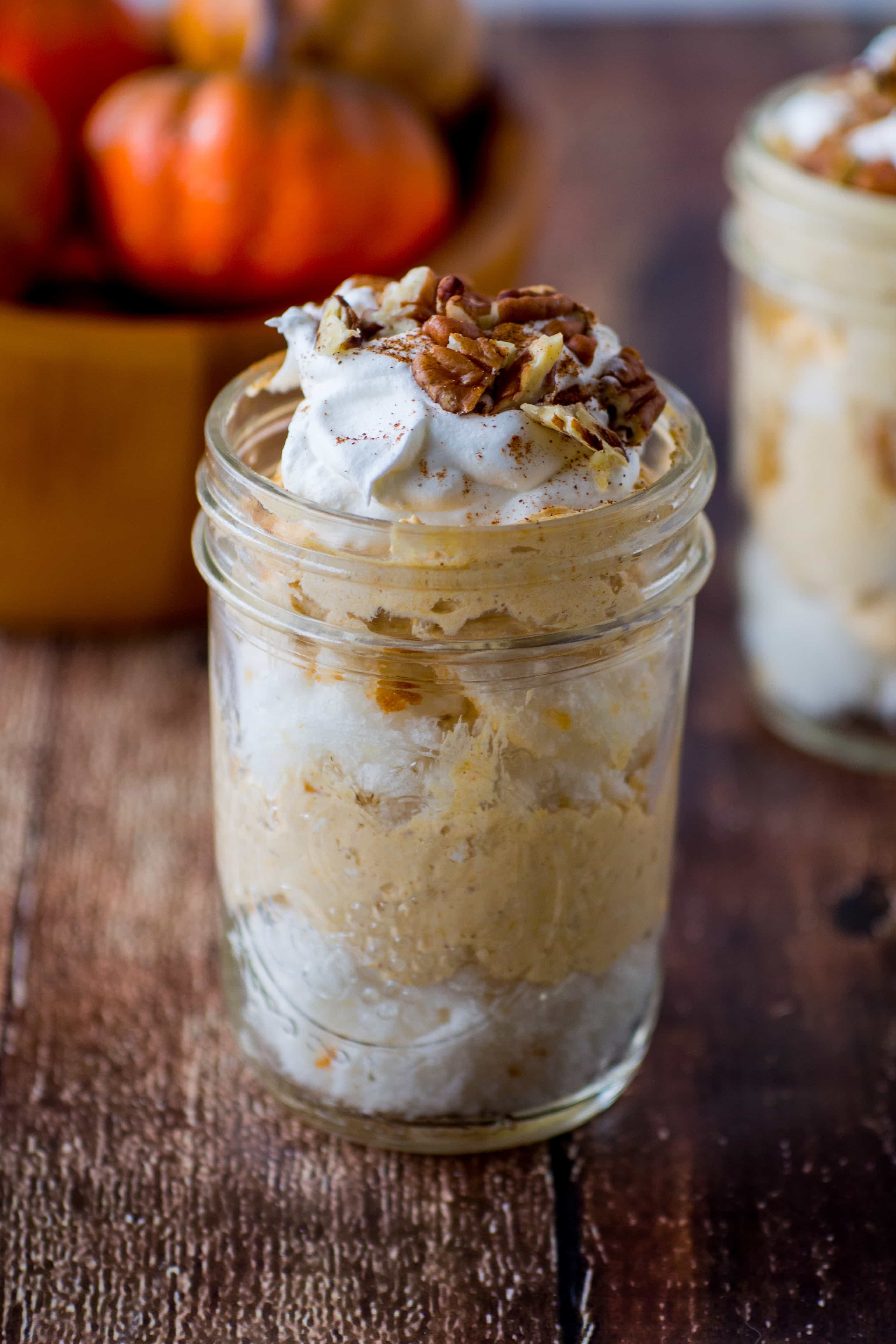This Pumpkin Cheesecake Trifle is made by layering store bought angel food cake in a mason jar with pumpkin cheesecake filling and topping it off with whipped topping and pecans. The pumpkin trifle is a seasonal dessert that is both elegant and easy, nice enough for Thanksgiving or Christmas, yet easy enough to make for a family dinner. #pumpkin #trifle #thanksgiving #dessert