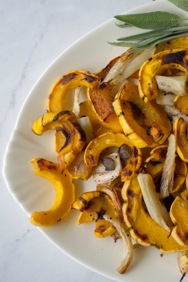This recipe Roasted Delicata Squash and Fennel is quick and easy to prepare, since the squash doesn't have to be peeled. The delicata squash is roasted with fennel and maple syrup for a sweet and savory side dish for fall meals. #Thanksgiving #wintersquash #delicatasquash #fennel