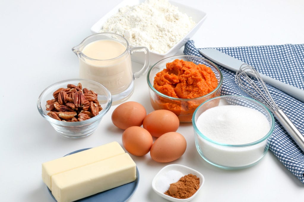 ingredients gathered for dump cake - eggs, pumpkin, sugar, spices, milk, cake mix