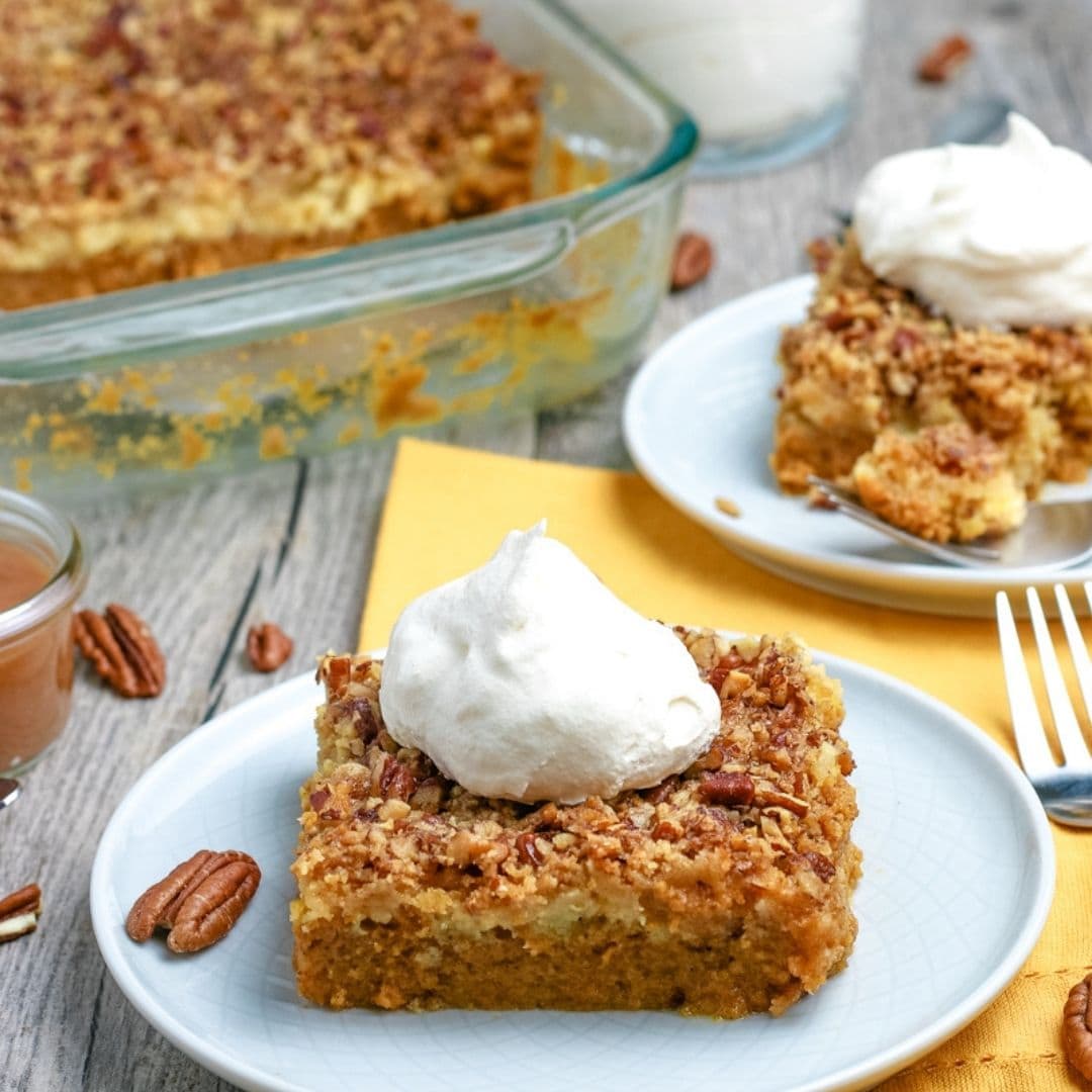 Pumpkin Dump Cake on a plate with whipped cream.