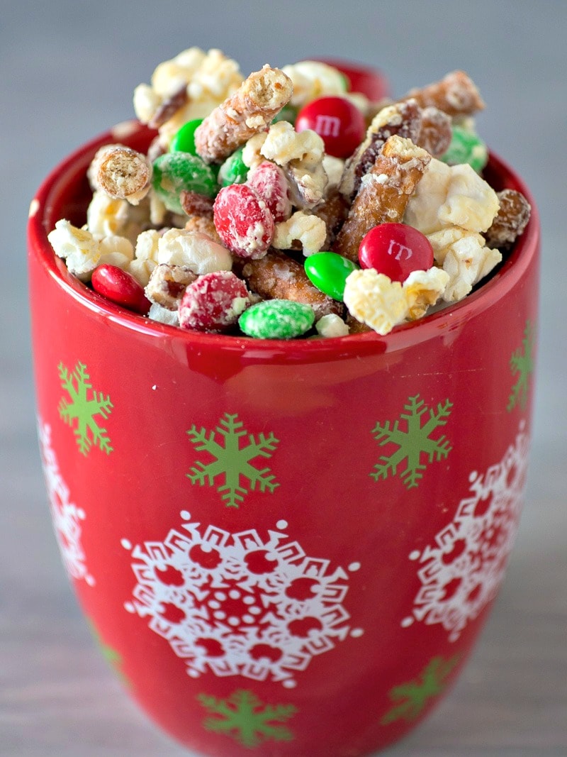 This easy white chocolate popcorn recipe is simple yet delicious! Popcorn, pretzels, pecans and M&Ms drizzled with white chocolate - yum! Easy to make and is perfect for family movie night or giving to friends and neighbors as a gift. #christmas #homemade #easyfoodgifts #popcorn