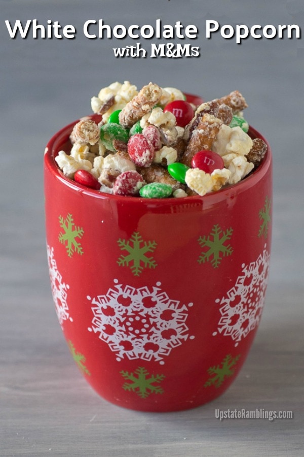 This easy white chocolate popcorn recipe is simple yet delicious! Popcorn, pretzels, pecans and M&Ms drizzled with white chocolate - yum! Easy to make and is perfect for family movie night or giving to friends and neighbors as a gift. #christmas #homemade #easyfoodgifts #popcorn