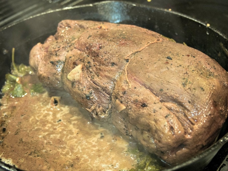 Searing the beef tenderloin roast in a cast iron skillet