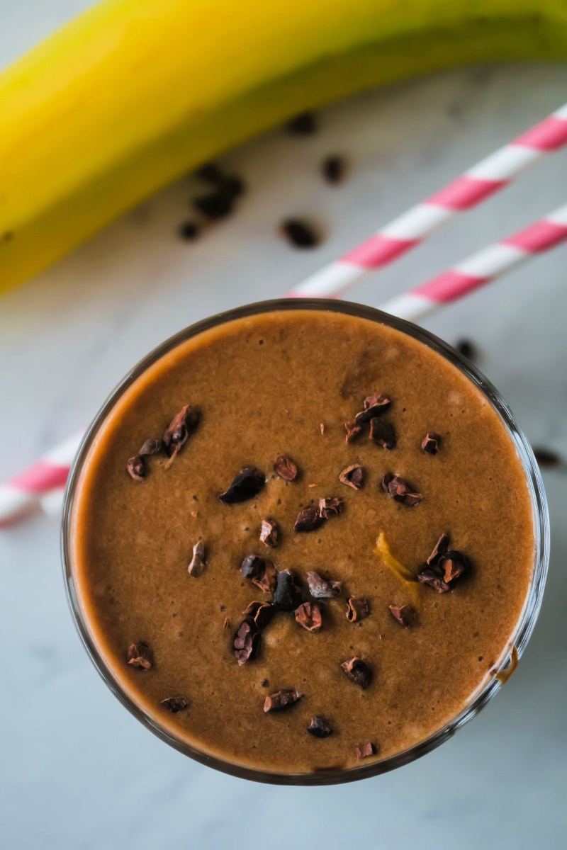 This healthy chocolate peanut butter smoothie with bananas has only four ingredients, takes less than 5 minutes to make and is a decadent vegan creamy chocolate smoothie perfect for breakfast or a snack. An easy dairy free recipe using almond milk, banana, cocoa powder, peanut butter and ice - no yogurt, no sweetener. #smoothie #chocolate