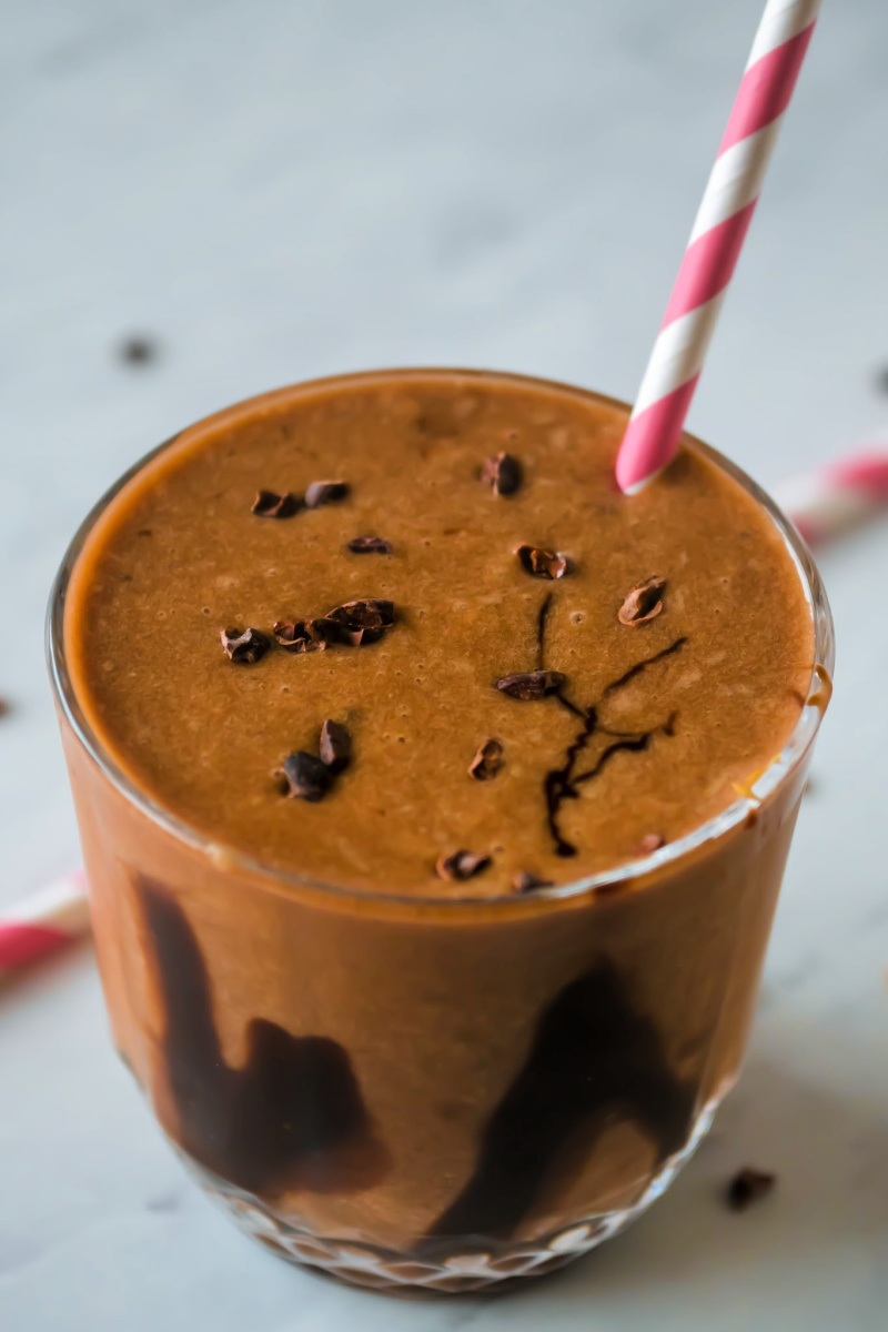 This healthy chocolate peanut butter smoothie with bananas has only four ingredients, takes less than 5 minutes to make and is a decadent vegan creamy chocolate smoothie perfect for breakfast or a snack. An easy dairy free recipe using almond milk, banana, cocoa powder, peanut butter and ice - no yogurt, no sweetener. #smoothie #chocolate